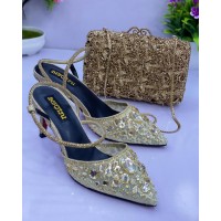Women shoe gold with a gold clutch purse
